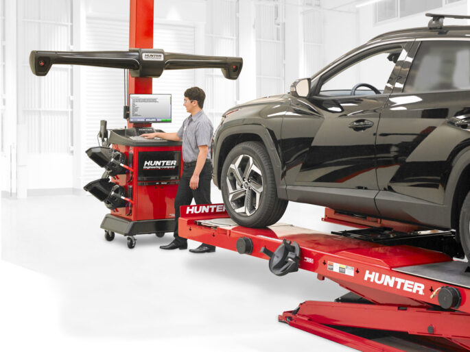 Man performing wheel alignment on Hyundai Tuscon with Hunter Engineering WinAlign Lite machine