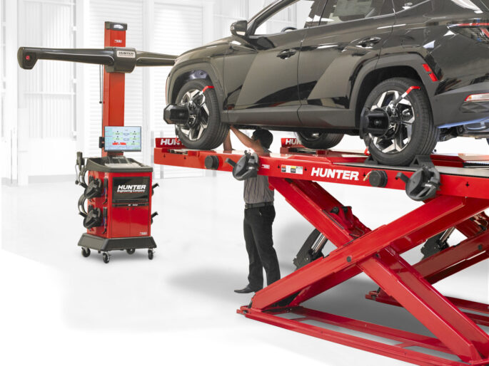 Man performing wheel alignment on Hyundai Tuscon with Hunter Engineering WinAlign Lite machine