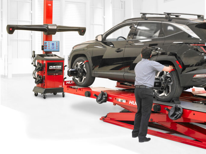 Man performing wheel alignment on Hyundai Tuscon with Hunter Engineering WinAlign Lite machine