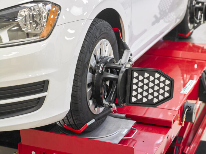 Car on hoist with Hunter Engineering QuickGrip adaptor attached to wheel